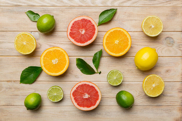 Flat lay of citrus fruits like lime, orange and lemon with lemon tree leaves on light colored background. Space for text healthy concept. Top view. - Foto, immagini
