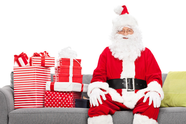 Santa on sofa full of presents - Foto, Bild