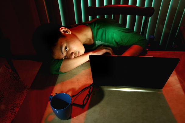 Jonge tiener slapen voor een laptopcomputer - Foto, afbeelding