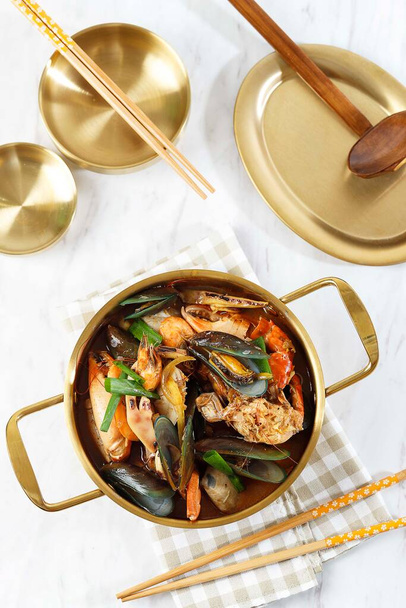 Korean Soup Jjampong, Mix Seafood Spicy Red Noodle, Chinese Food. Top View on Gold Pan  - Фото, изображение