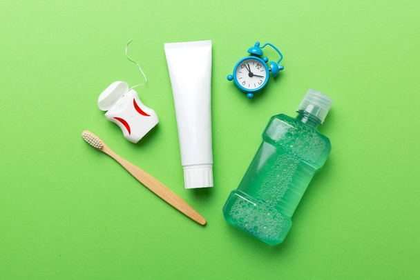 Mouthwash and other oral hygiene products on colored table top view with copy space. Flat lay. Dental hygiene. Oral care products and space for text on light background. concept. - Photo, Image