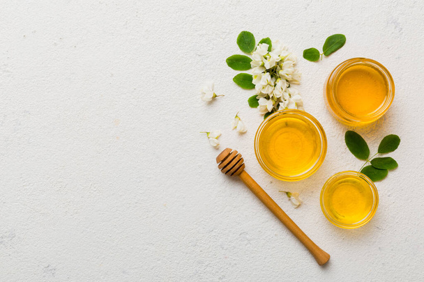 honey jar with acacia flowers and leaves. fresh honey top view flat lay. - Фото, зображення