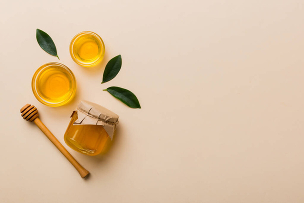Pot à miel avec trempette à miel en bois sur fond blanc vue de dessus avec espace de copie. Délicieuse bouteille de miel. - Photo, image