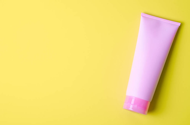 The Empty a cosmetic pink tube of cream on green background with empty space for your text. - Photo, image