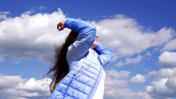 boldog gyermek őszi kabát élvezze a hosszú szeles haj az égen háttér, frizura. - Felvétel, videó