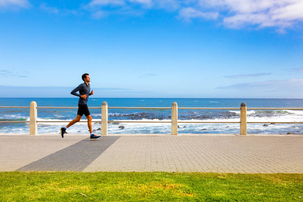 Cape Town, South Africa - May 12, 2022: Jogger on Sea Point promenade on the Atlantic Seaboard - Foto, imagen