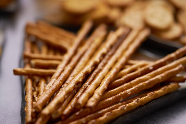 Close up of Salty sticks on a plate with crackers. Traditional beer and party snacks - Photo, Image