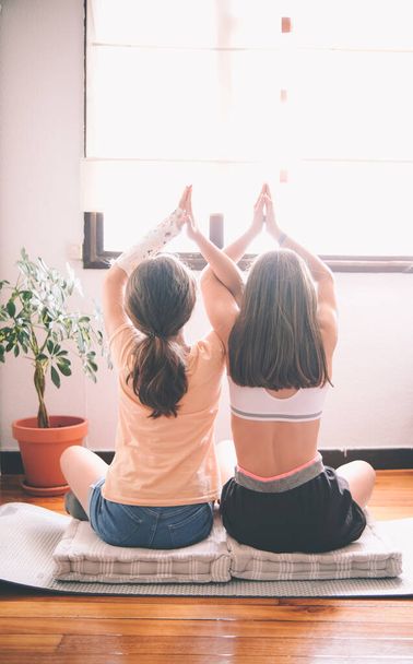 jeune couple pratiquant le yoga dans la chambre - Photo, image
