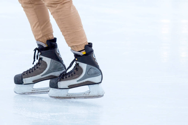 Jégkorcsolyázás egy jégpályán. Korcsolyás lábak. Téli aktív sport és szabadidős hobbi. - Fotó, kép