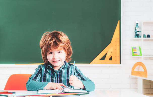 Portrait of Pupil of primary school study indoors. Pupil learning letters and numbers. Cute little preschool kid boy with teacher study in a classroom - Photo, image