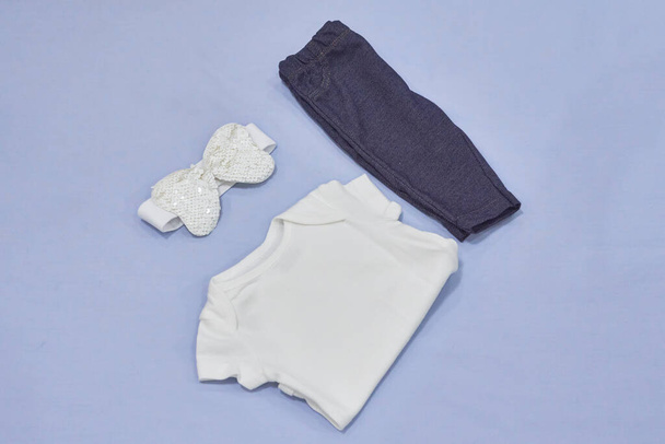 Mockup de la camisa blanca del traje del bebé, vaqueros y diadema en fondo azul - Foto, Imagen
