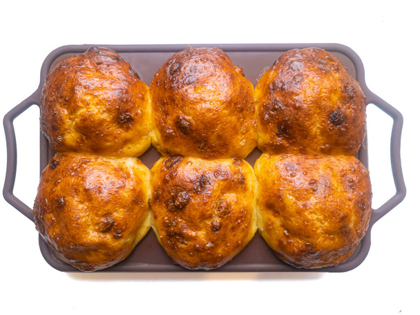 Lush buns with a golden crust in a silicone mold on top. - Foto, afbeelding
