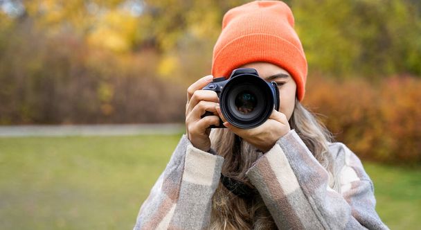 Girl with camera outdoors. Woman takes pictures. Hobby leisure or profession - Photo, Image