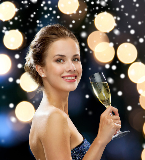 sonriente mujer sosteniendo un vaso de vino espumoso
 - Foto, imagen