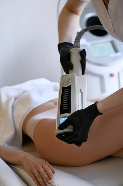 Beautiful woman enjoys buttocks massage with endosphere machine for anti-cellulite and body correction - Zdjęcie, obraz