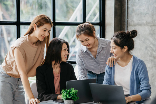A group of young Asian business women stand and talk. Jointly open a startup company and a business plan management plan to grow the business and be profitable by the concept of the new generation. - Foto, imagen