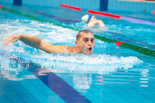 Male swimmer swims in the pool. - Foto, imagen