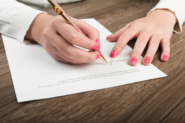 Les mains d'une femme d'affaires signent un contrat
. - Photo, image