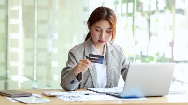 Beautiful woman holding a credit card, she uses a credit card to pay for goods and services online, the concept of using a credit card for online shopping, ordering goods and services on the website. - Filmmaterial, Video
