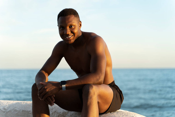 Handsome young cheerful man at beach. Shirtless man at beach enjoying of the sun while smiling to the camera  - Zdjęcie, obraz