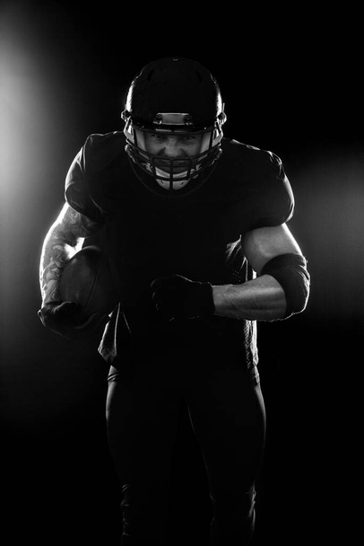 American Football player on black background with copy space - Fotó, kép
