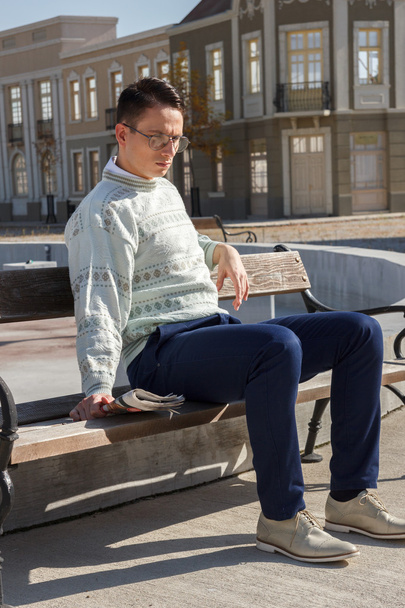 homem com óculos em suéter branco situado no banco e segurando ne
 - Foto, Imagem