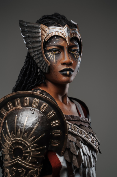 美しい鋼の鎧を着た灰色の武道のアフリカの女性戦士に孤立した肖像画. - 写真・画像