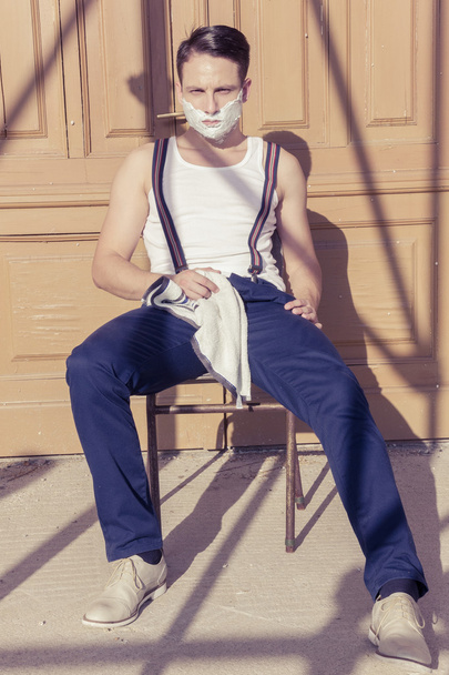 чоловік з піною для гоління на обличчі і рушником навколо шиї
 - Фото, зображення