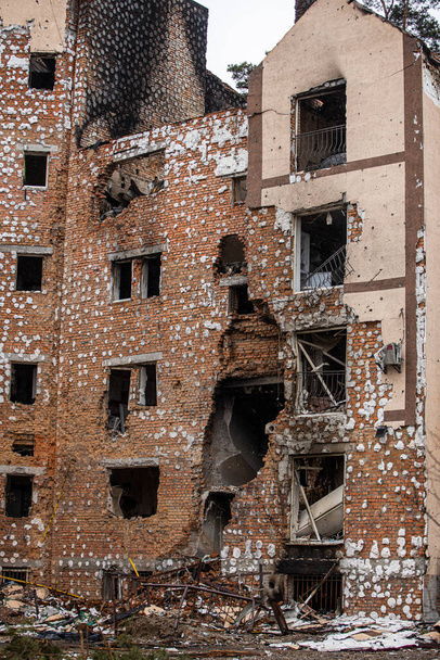 Städte der Ukraine nach der russischen Besatzung. Zerstörte Gebäude in den Straßen von Irpen. Zerbrochene, beschossene Fenster. Gebäude nach Raketeneinschlag. - Foto, Bild