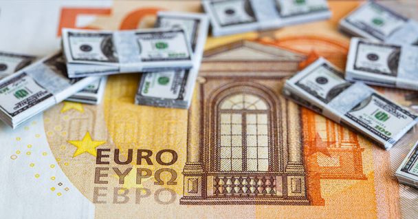 pacchetti di banconote in miniatura da 100 dollari su sfondo di banconote in euro 50 a scopo di progettazione - Foto, immagini