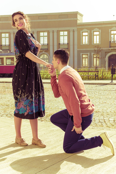 jonge man geknield en vragen een meisje met hem te trouwen in het park op - Foto, afbeelding