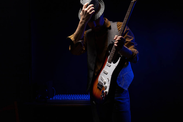 Facet gra na gitarze elektrycznej. Muzyk w studio nagraniowym trzymający gitarę elektryczną - Zdjęcie, obraz
