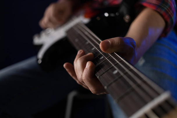 Hombre tocando la guitarra eléctrica. Músico en estudio de grabación sosteniendo guitarra eléctrica - Foto, imagen