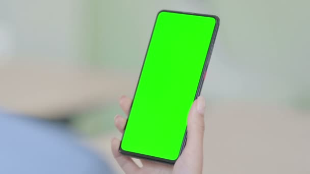Mujer joven usando Smartphone con pantalla clave de croma verde  - Metraje, vídeo