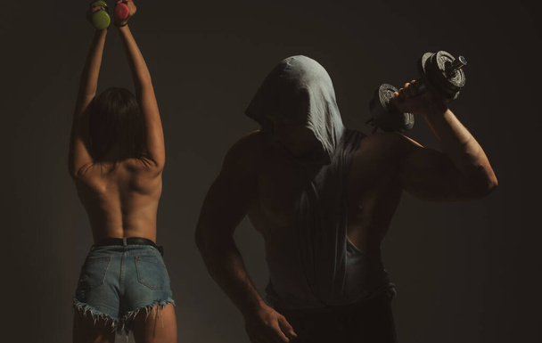 Sporty sexy couple with dumbbells on black studio background - Valokuva, kuva