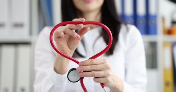 The doctor folds the stethoscope into the shape of a heart, close-up. Diagnosis of cardiovascular diseases, consultation with a cardiologist - Footage, Video