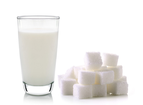 pohár tej és elszigetelt fehér hát nádcukrot kocka - Fotó, kép