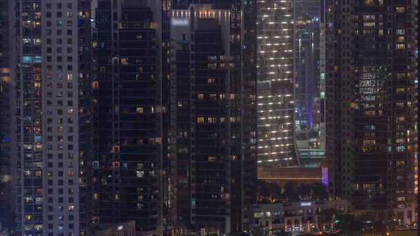 Dubai 'deki Business Bay' de parlayan pencereleri olan gökdelenler. Çimenli ve palmiyeli park, Birleşik Arap Emirlikleri - Fotoğraf, Görsel