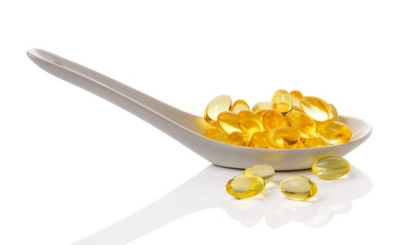 Olej z wątroby dorsza omega-3 kapsułek żelowych w łyżką na białym tle - Zdjęcie, obraz