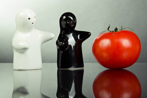 Две керамические фигуры указывают на помидор
 - Фото, изображение