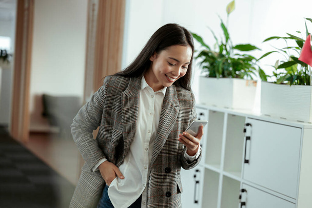 Asian business woman making a phone call and smiling. High quality photo - Photo, Image