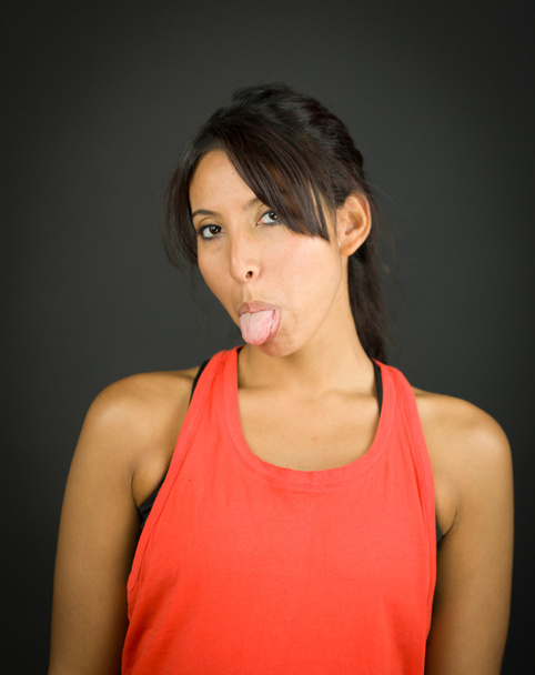 Retrato de uma jovem mulher salientando a língua
 - Foto, Imagem