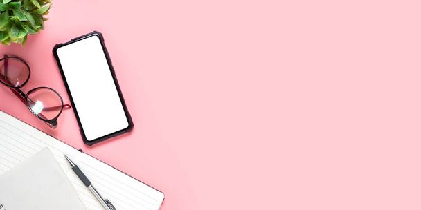 Escritorio de oficina con pantalla en blanco teléfono inteligente, pluma, portátil, gafas sobre fondo rosa, vista superior con espacio para copiar, Maquillaje. - Foto, Imagen