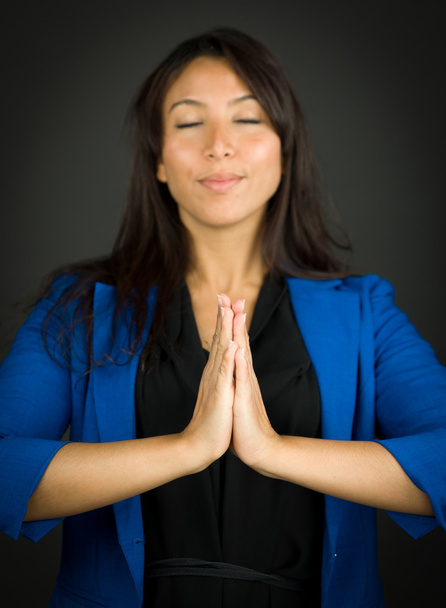 junge Geschäftsfrau in Gebetsposition mit meditierend umklammerten Händen - Foto, Bild