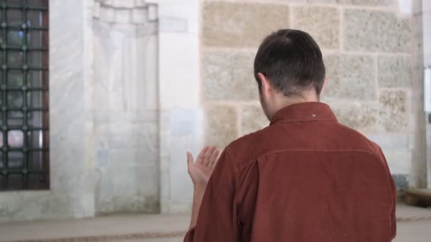 Moslimjongeman bidt tot God met open handen, palmt omhoog naar de hemel, vraagt God om vergeving, doet een wens volgens de islamitische regels - Video