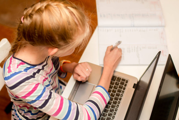 Tini lány ül laptop és notebook - online tanulás otthonról. Iskolai házi feladatot csinálok. - Fotó, kép