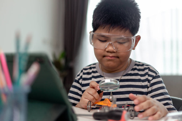 Young asia student remotely learn online at home  in coding robot car and electronic board cable in STEM, STEAM, mathematics engineer science technology computer code in robotics for kids. - Photo, Image
