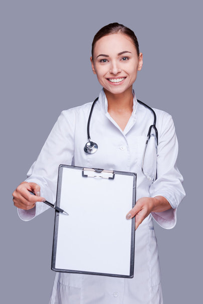 Female doctor  stretching out clipboard - Foto, Bild