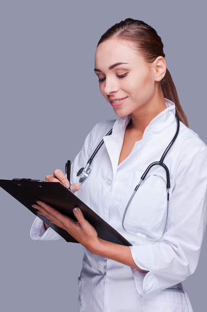 Female doctor writing in clipboard - Photo, image