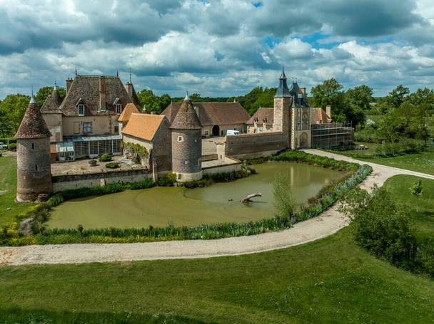 Veduta aerea di Chteau de la Cour-en-Chapeau nell'Allier Francia costruita con mattoni neri a forma di diamante su uno sfondo di mattoni rossi, palazzo, torre del cancello, torri angolari e fossato - Foto, immagini